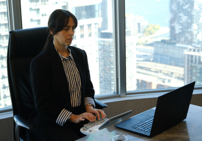 Court reporter typing on stenotype machine