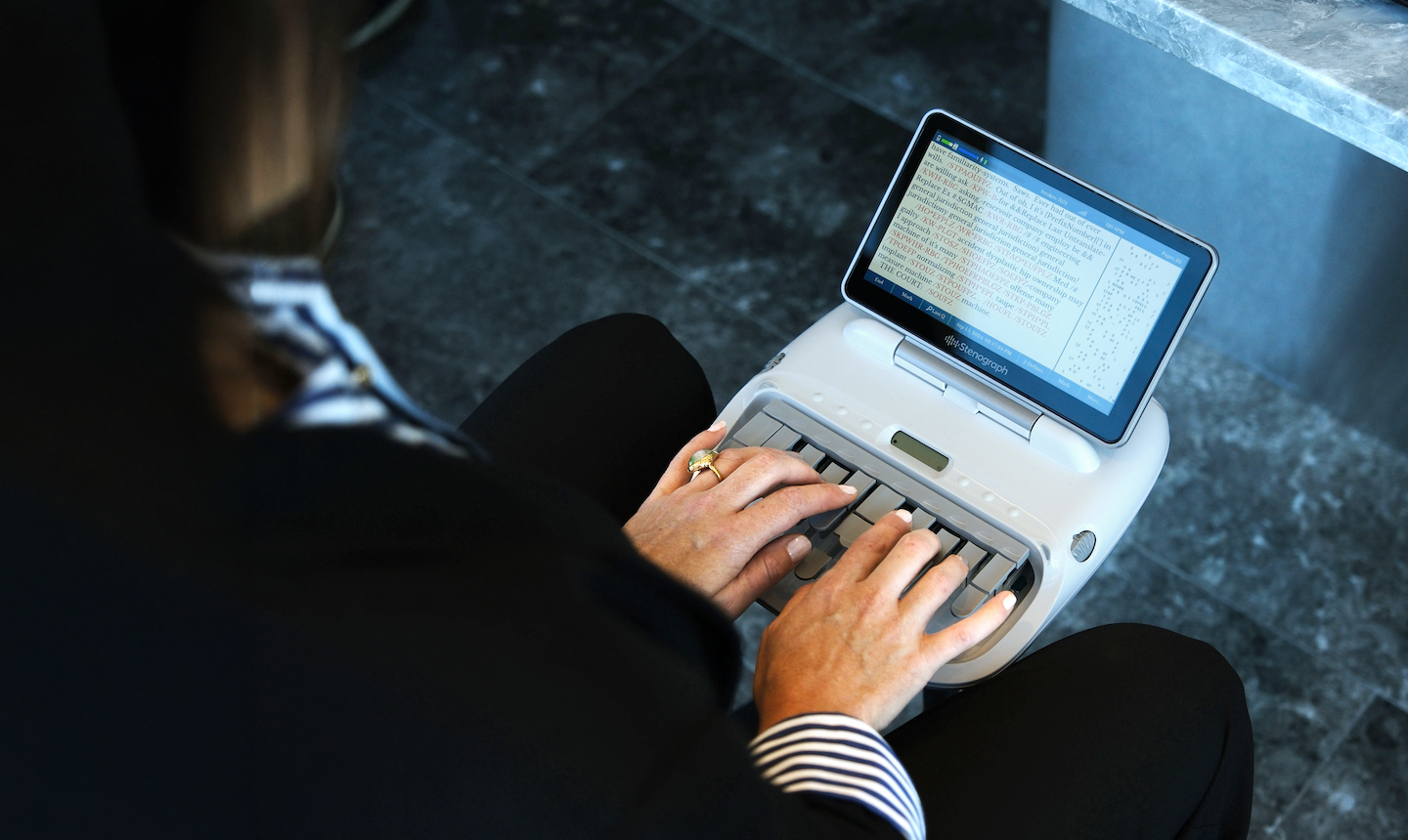 Court reporter types on stenograph